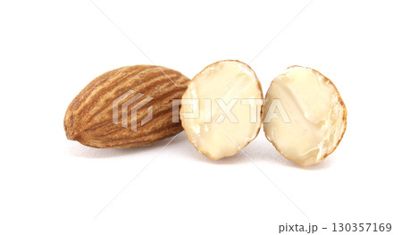 A detailed view of almonds, with a whole one and two cut-open halves against a white background. A detailed view of almonds, with a whole one and two cut-open halves against a white background. 130357169