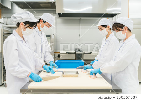 鶏肉を調理するコックコート姿の男女スタッフ(調理師・料理人・生鮮市場・食品加工) 鶏肉を調理するコックコート姿の男女スタッフ(調理師・料理人・生鮮市場・食品加工) 130357587