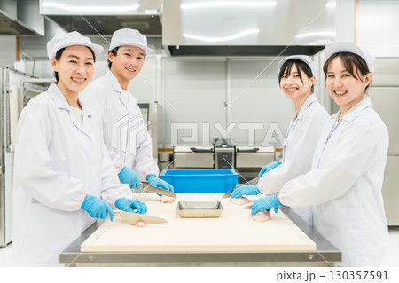 鶏肉を調理するコックコート姿の男女スタッフ（調理師・料理人・生鮮市場・食品加工） 130357591