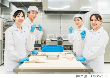 鶏肉を調理するコックコート姿の男女スタッフ(調理師・料理人・生鮮市場・食品加工) 鶏肉を調理するコックコート姿の男女スタッフ(調理師・料理人・生鮮市場・食品加工) 130357592
