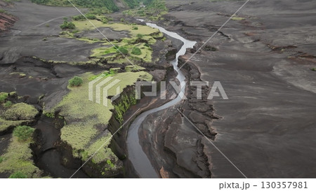 Fiji, Tana Island: Aerial view capturing a river winding through the volcanic landscape of Port Resolution, Tana Island, Fiji, highlighting unique geology and lush vegetation. Drone flight 130357981