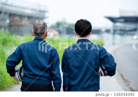 建設現場を支える2人の背中 130358393