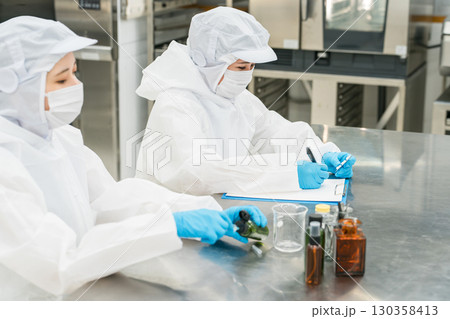 薬品工場,製薬会社で薬品開発をするクリーンスーツを着たスタッフ 薬品工場,製薬会社で薬品開発をするクリーンスーツを着たスタッフ 130358413