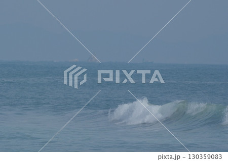 湘南に打ち寄せる波、遠く霞むえぼし岩、そして漁船 130359083