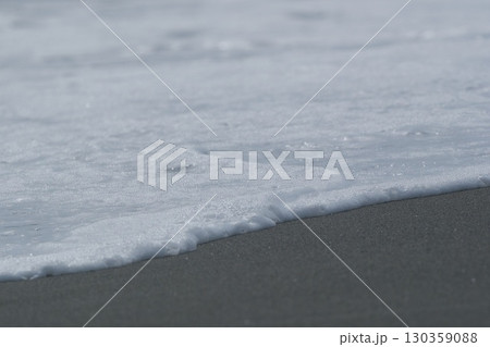 砂浜に寄せた波の先端の泡 130359088