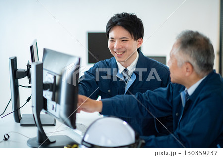 オフィスで会話するベテランと若手 オフィスで会話するベテランと若手 130359237