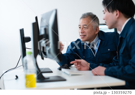 オフィスで会話するベテランと若手 オフィスで会話するベテランと若手 130359270