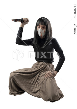 Indonesian southeast asian man dressed as a woman wearing a bloody face mask and holding a bloody knife isolated over a white background. Concept of Halloween, Sister Hong, or red uncle 130360215