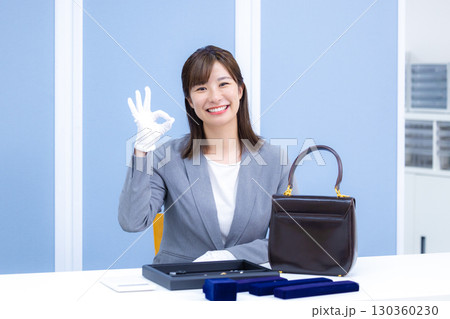 買取業者　窓口で査定をしている女性 130360230