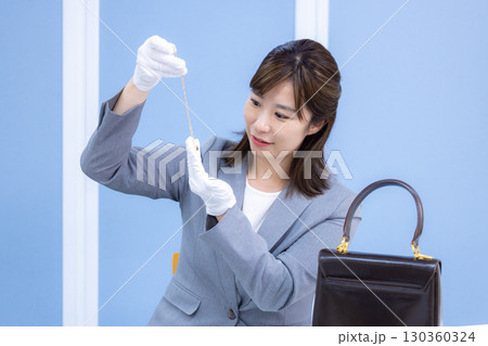 買取業者 窓口で査定をしている女性 買取業者 窓口で査定をしている女性 130360324