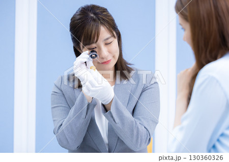 買取業者　窓口で査定をしている女性 130360326