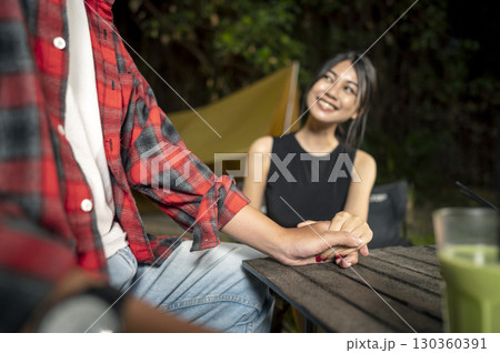 Indonesian southeast asian couple holding hands. The scene of love, togetherness, or cheating in a relaxed setting. The scene of the lifestyle of camping in a natural setting Indonesian southeast asian couple holding hands. The scene of love, togetherness, or cheating in a relaxed setting. The scene of the lifestyle of camping in a natural setting 130360391