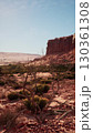 A view of a desert area in Nevada featuring a prominent rock formation in the background under the clear sky. 130361308