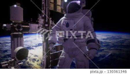 An astronaut in a white space suit conducts a spacewalk, floating beside the International Space Station above Earth. The vastness of space and the planet are visible in the background. 130361346