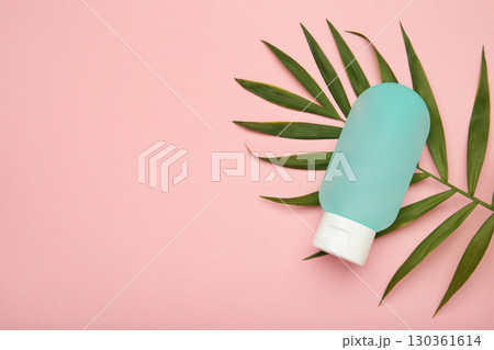 Cosmetic bottle with green leaves on pink background. Space for text Cosmetic bottle with green leaves on pink background. Space for text 130361614