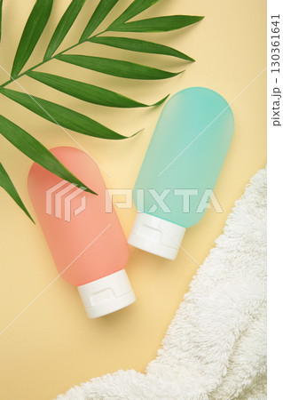 Travel bottles with body care cosmetics on beige background 130361641