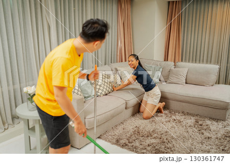 Couple Cleaning Living Room Together, Creating a Cozy Home Environment Couple Cleaning Living Room Together, Creating a Cozy Home Environment 130361747