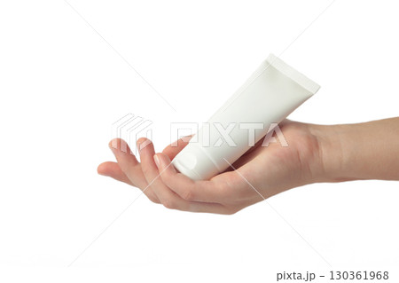 Hand holding blank white plastic tube isolated on white background. 130361968