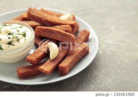 Garlic bread snack for beer. Rye bread croutons with garlic sauce on grey. Garlic bread snack for beer. Rye bread croutons with garlic sauce on grey. 130361980