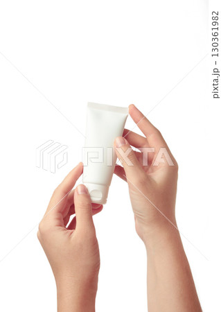 Hand holding blank white plastic tube isolated on white background. Hand holding blank white plastic tube isolated on white background. 130361982