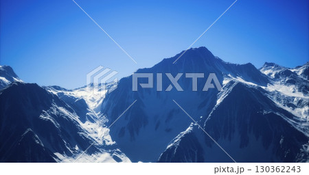 Towering mountain range with snow covered summits against a clear blue sky, showcasing the beauty of natures rugged terrain during daytime, inviting exploration and adventure. Towering mountain range with snow covered summits against a clear blue sky, showcasing the beauty of natures rugged terrain during daytime, inviting exploration and adventure. 130362243