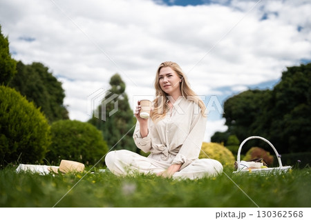 Enjoying a serene picnic in a lush garden under a cloudy sky Enjoying a serene picnic in a lush garden under a cloudy sky 130362568