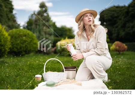 Enjoying a peaceful afternoon picnic in a lush green park setting Enjoying a peaceful afternoon picnic in a lush green park setting 130362572