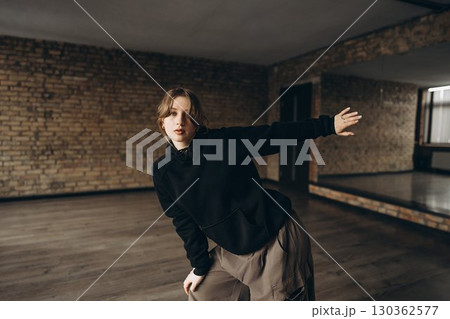 Young dancer practicing in an urban studio with exposed brick walls Young dancer practicing in an urban studio with exposed brick walls 130362577