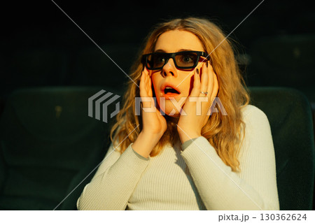 Audience member reacts with surprise while watching a thrilling movie 130362624