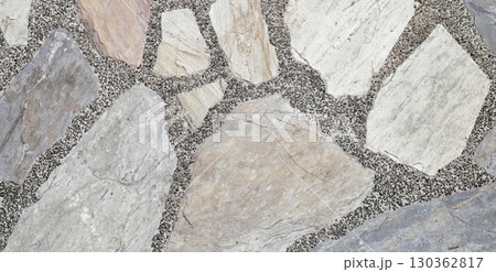 Decorative stone pavement with irregularly shaped natural rocks set in concrete. 130362817