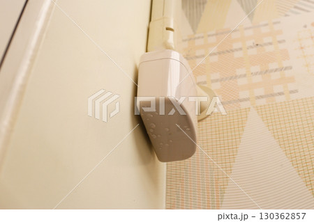 Wall-mounted drain pump for air conditioner with water droplets underneath, indicating malfunction or leakage. 130362857