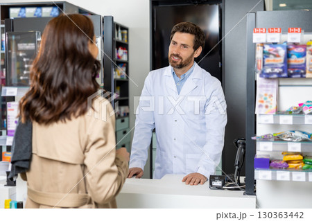 Female customer talking to a pharmacist and both looking involved Female customer talking to a pharmacist and both looking involved 130363442