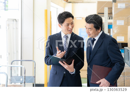 倉庫で会議をするミドルのビジネスマン 130363529