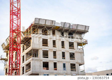 Construction site with cranes and concrete structures during active building process. Concept of modern urban development, housing expansion and civil engineering. 130363754