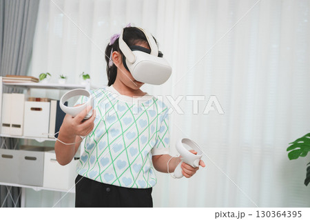 Child's interactive virtual reality experience. A kid with VR goggles playing a 3D simulation game. 130364395