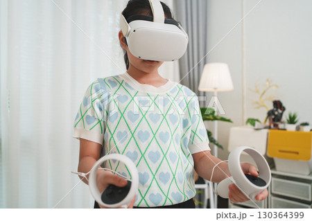 A young student uses a VR headset for interactive lesson, transforming education. This is the future of virtual learning and immersive EdTech at home. 130364399