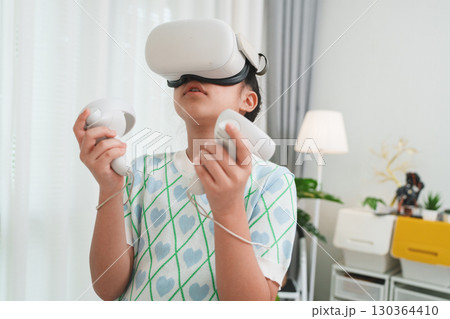 Girl exploring metaverse with VR goggles for virtual learning and simulation. Girl exploring metaverse with VR goggles for virtual learning and simulation. 130364410