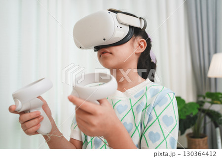 Girl Using Virtual Reality Headset for Immersive Education at Home 130364412