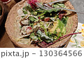Colorful vegan salad with falafel, avocado, grapes and greens served in a rustic bowl with creamy dressing 130364566