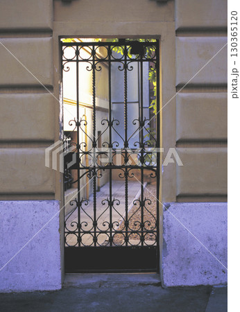 ローマ市内の古い町並み アパートの裏庭へ続く装飾門扉 130365120