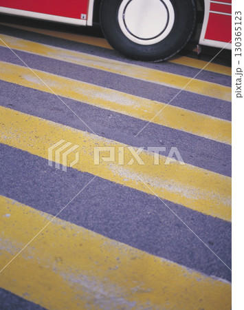 ローマ市内の古い町並み 道路に描かれた黄色いラインと赤いバスの車輪 130365123