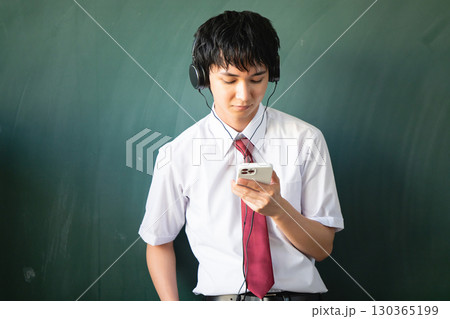 ヘッドホンで音楽を聴く男性 130365199