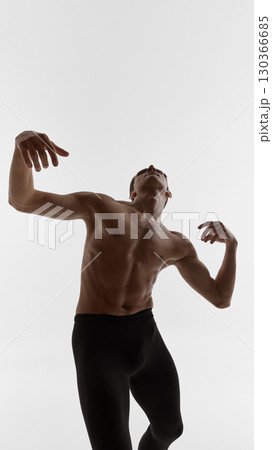 Male dancer twisting torso upward with expressive hands and emotional vulnerability 130366685