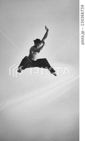 Male performer leaping with sharp arms expressive intensity and dramatic focus Male performer leaping with sharp arms expressive intensity and dramatic focus 130366739