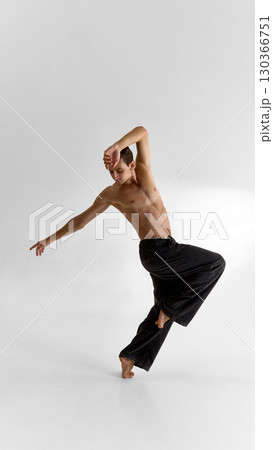 Expressive male dancer in fluid motion pose with bare torso and emotional focus 130366751