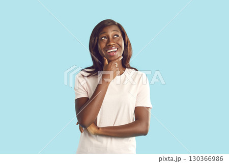 Portrait of young african american woman looking to the side isolated on studio blue background. 130366986