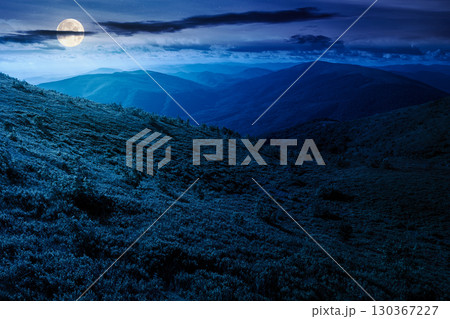 mountain landscape in summer at night. beautiful view of rolling green hills and alpine meadows in full moon light. scenery with clouds on the dark sky. scenic nature background for travel 130367227