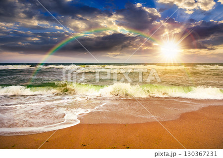 stormy beach scenery with waves splash on sand shore under scenic clouds on the sky at sunset. dark moody nature background for travel. scenic view of european coast in evening light stormy beach scenery with waves splash on sand shore under scenic clouds on the sky at sunset. dark moody nature background for travel. scenic view of european coast in evening light 130367231