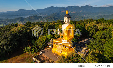 Aerial view of A golden Buddha statue on the mountains 130368846