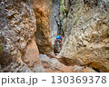 Climber on via ferrata trail, crossing a deep canyon. 130369378